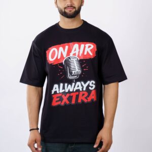 Young man in Delhi wearing an oversized black t-shirt with 'On Air Always Extra' printed, studio shot.